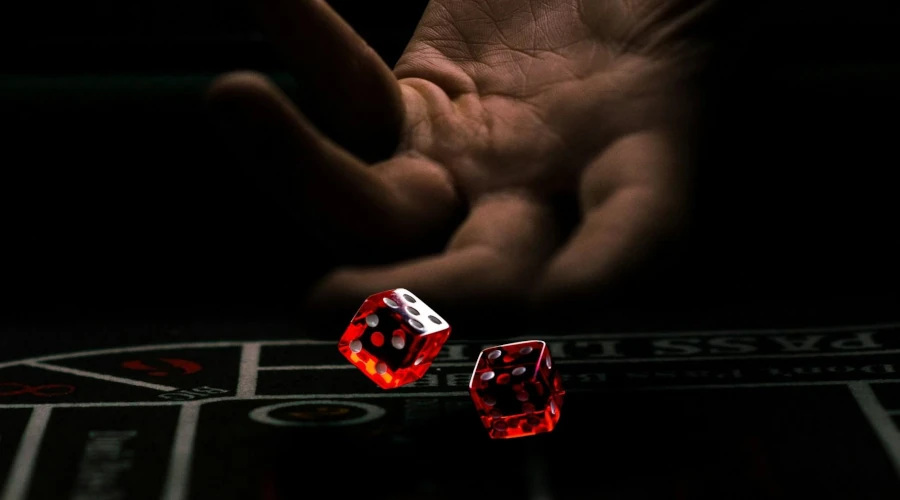 Hand pointing at dice symbolizing privacy-focused online casino play in 2026